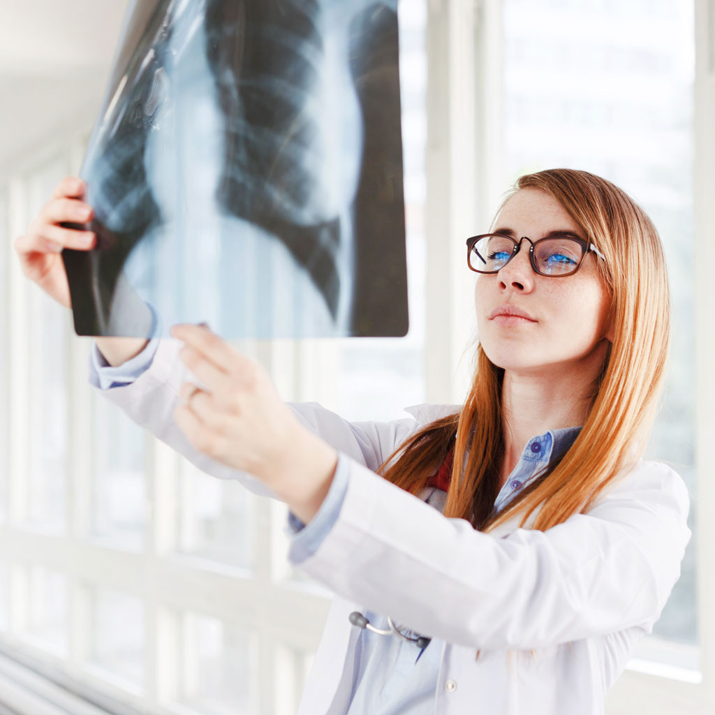 young-female-doctor-looking-at-the-x-ray-picture-o-6MGQ3JL